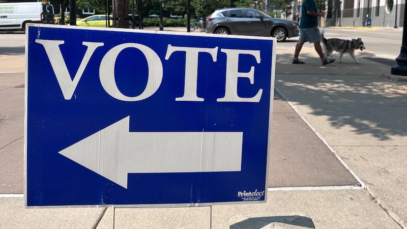 A person walks past a sign for a polling place on the first day of in-person absentee voting...