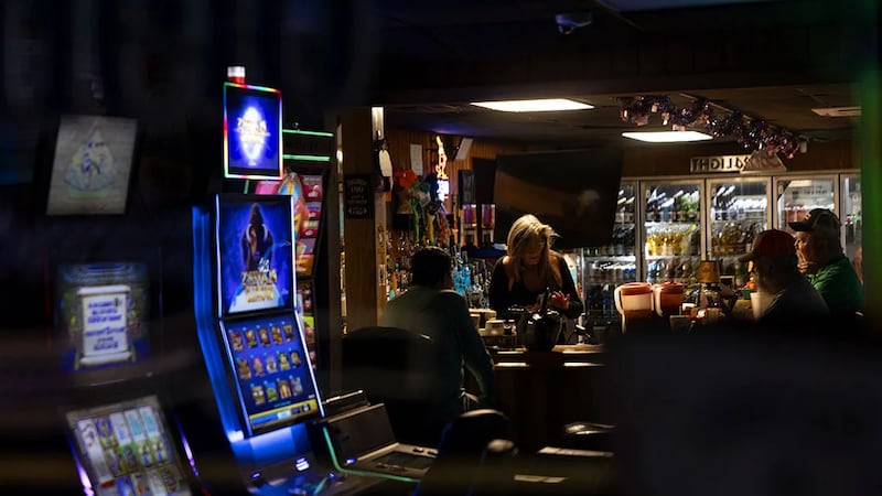 Slot machines light up the front window of a bar in Golconda, Illinois. (Credit: Julia...