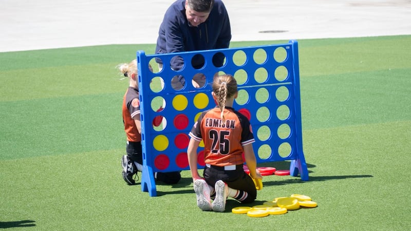 Gov. JB Pritzker plays Connect 4 with children following an event to open a new sports park in...